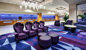 Four stylized, high back arm chairs in front of 3 round ottomans in a spacious lobby
Four stylized, high back arm chairs in front of 3 round ottomans in a spacious lobby
