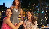 Three women enjoy drinks and appetizers at an outdoor table
Three women enjoy drinks and appetizers at an outdoor table