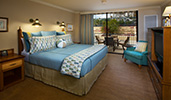 A king bed with 2 night stands across from an arm chair and a dresser with a TV
A king bed with 2 night stands across from an arm chair and a dresser with a TV