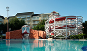 A pool with a waterslide has a Boardwalk carnival clown motiff
A pool with a waterslide has a Boardwalk carnival clown motiff