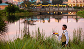 A Cast member carrying a tray of drinks outdoors by the water A Cast member carrying a tray of drinks outdoors by the water