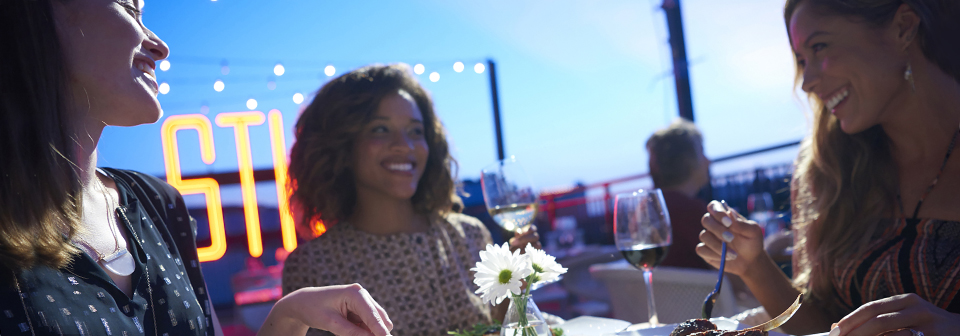 3 women smile, eat and drink at a restaurant table 3 women smile, eat and drink at a restaurant table