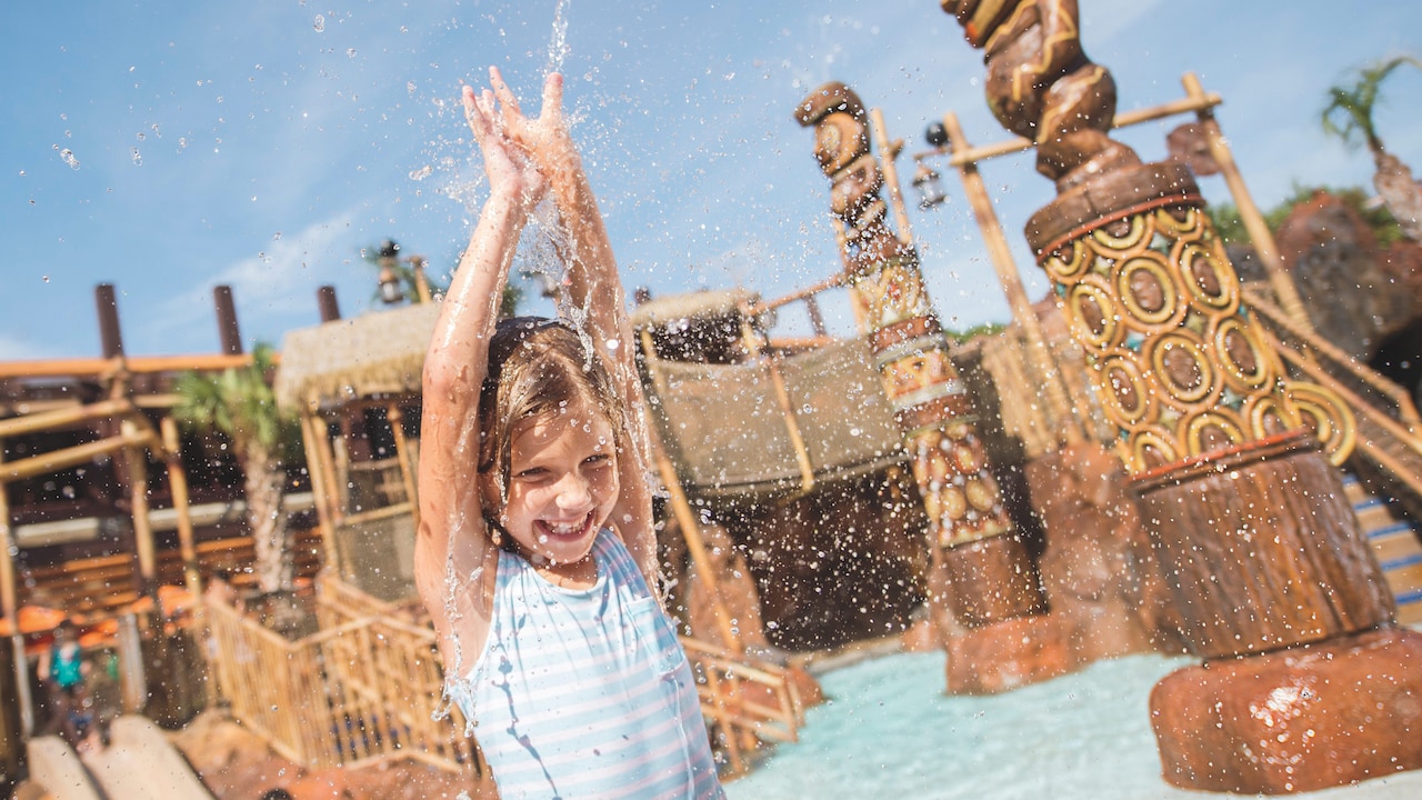 A young female Guest splashing about around a water play area at Disney’s Polynesian Village Resort
