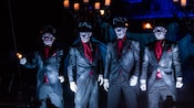 Members of the Cadaver Dans perform on a graveyard-themed raft on the Rivers of America at night