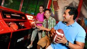 Guys test their football tossing skills at ESPN Zone Sports Arena and arcade