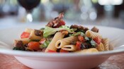 Rigatoni with Italian sausage, mushrooms, tomatoes, olives and escarole in bowl