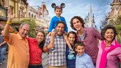Multiple generations of a multicultural family posing on Main Street, U.S.A. at Magic Kingdom park