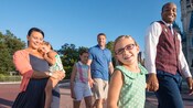 A young girl holds hands with a VIP Tour Guide as he guides her family through Magic Kingdom park