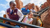 A VIP Tour Guide rides with a young female Guest while they both enjoy Big Thunder Mountain Railroad