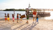 Little pirates marching on a beach halt as a Cast Member raises her hand