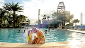 A mother and daughter sit on the edge of Bay Cove Pool at Bay Lake Tower at Disney’s Contemporary Resort