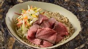 A slow-roasted sliced grilled beef bowl served with vegetable slaw, boba balls and brown rice