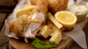 Fish and chips with tartar sauce and a lemon garnish