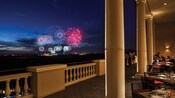 Evening fireworks blast off from a nearby theme park as Guests watch in wonder from the patio area