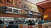 Line of five check-out registers in front of an open kitchen area at ABC Commissary