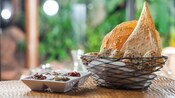 Traditional African breads and flatbreads in a wire basket, with a side dish of dips and condiments