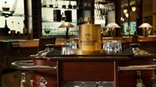 Dark wood and brass liquor cart with bottles on tumblers in the lounge section at Citricos