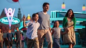Family holding hands while walking by Flo’s V8 Café in Disney California Adventure Park