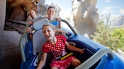A girl and her parents ride Matterhorn Bobsleds