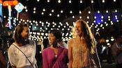 3 women enjoy the bright lights of the Downtown Disney area at night