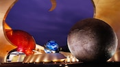 Large colorful planets lit-up at night at the entrance to Mission: SPACE