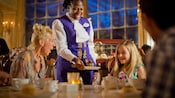 A mother looking on in amazement as her daughter receives a dessert from an excited Cast Member