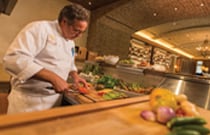 Culinary Offerings at Summerhouse A chef preps food in a restaurant kitchen