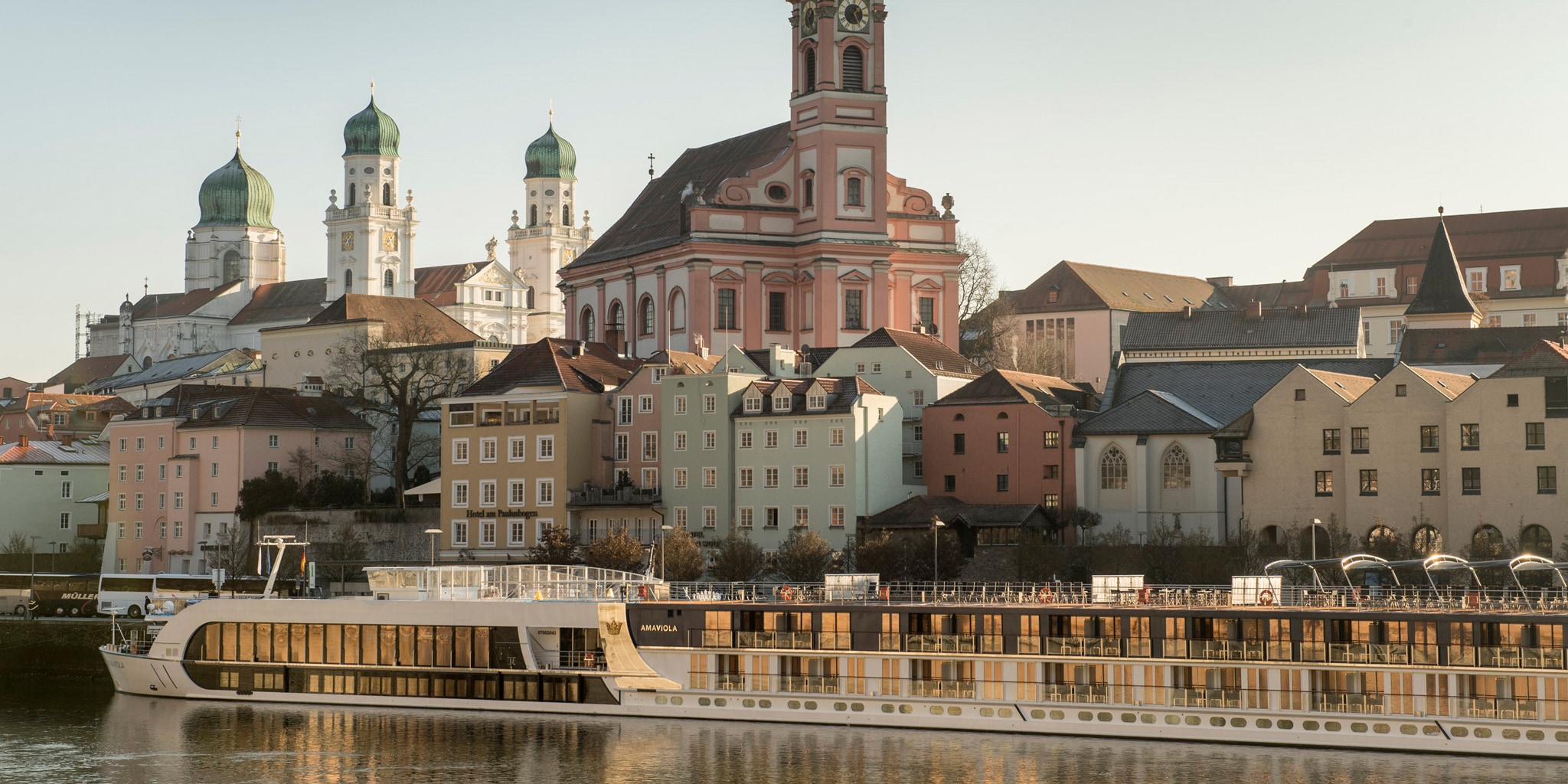 An AmaWaterways ship cruises along the Danube River past the town of Passau, Germany