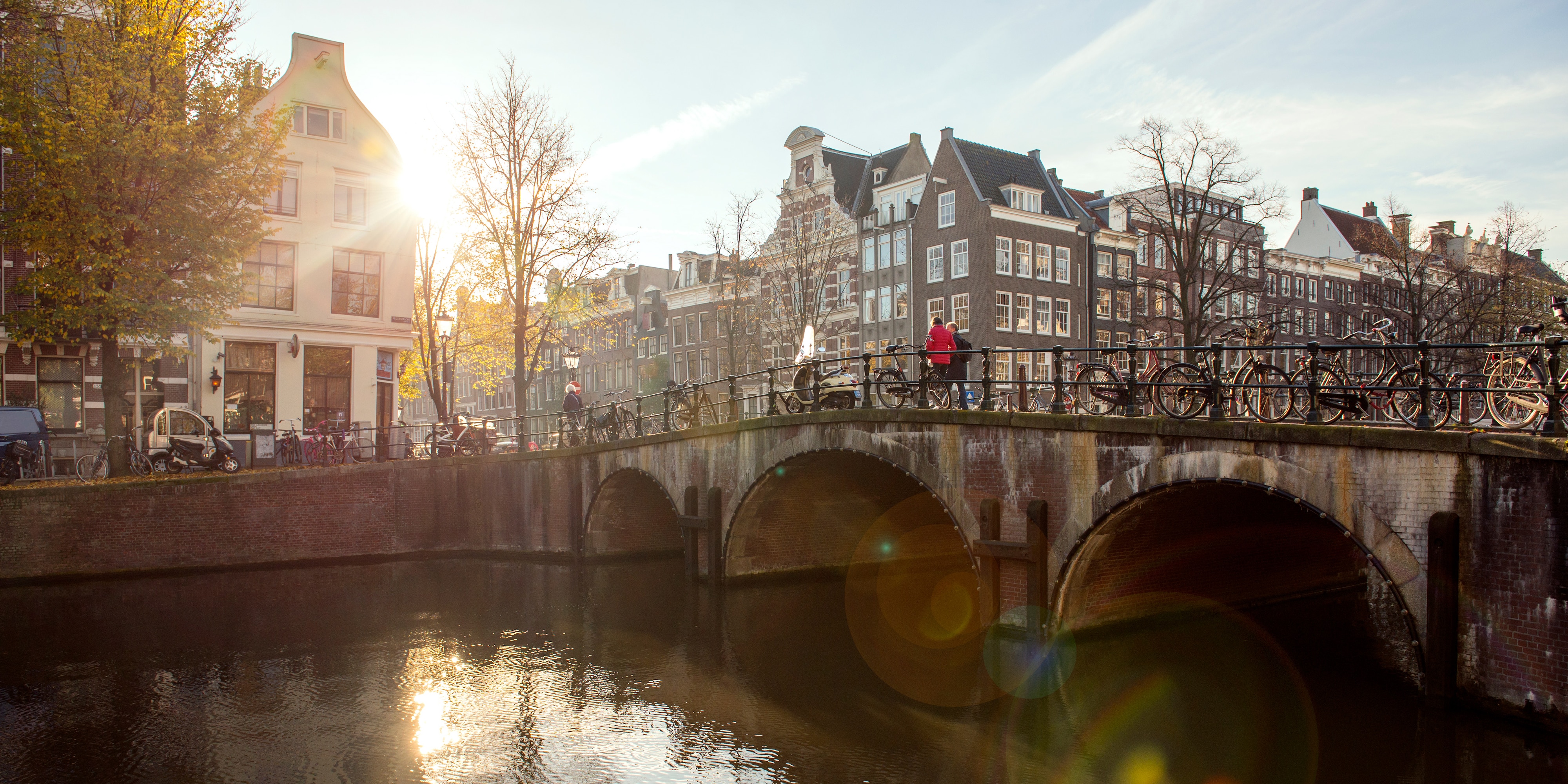 A stone bridge over a river leads to a quaint European village