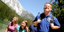 A mom, daughter and Adventure Guide hike through the wilderness