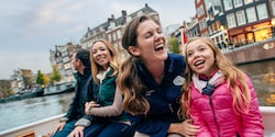 A group of Guests have fun with their Adventure Guide while sitting on the edge of a fountain
