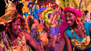 Male and female Discovery Island Carnivale performers dance at night at Disney’s Animal Kingdom park