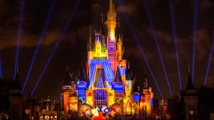 Vibrant lighting effects illuminate Cinderella Castle during Once Upon a Time at Magic Kingdom park