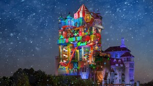 The Hollywood Toy Hotel lit up with lights near trees and falling snow