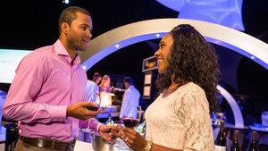 A couple drinks wine and holds hands at Party for the Senses, in Epcot at Walt Disney World Resort