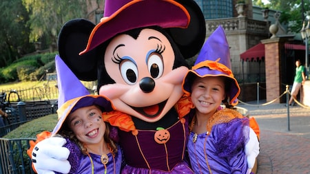 minnie mouse dressed as a witch and 2 girls wearing a minnie witch costume - Disney Halloween Orlando minnie mouse dressed as a witch and 2 girls wearing a minnie witch costume - Disney Halloween Orlando