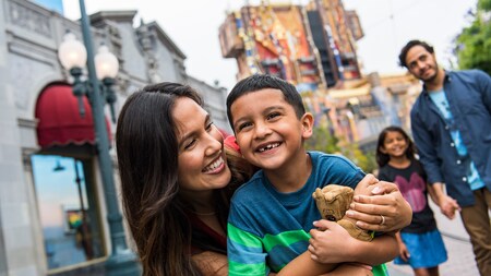 A mother, father, son and daughter walking outside at a theme park