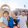 A mother holds her young son and a Mickey plush as her husband looks on within the courtyard of Disney’s All-Star Music Resort