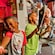 Dos niños pequeños sostienen alegremente espadas de juguete e interactúan con un Miembro del Elenco vestido como un pirata