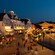 Guests stroll the waterfront boardwalk in the evening past Disney’s BoardWalk Inn