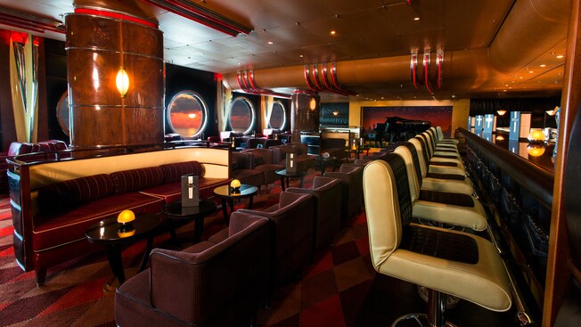 A woman and a man seated next to each other at a bar enjoy the cozy lounge atmosphere