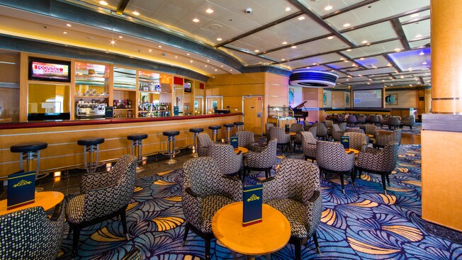 A large lounge features a long bar with stools and many tables with chairs