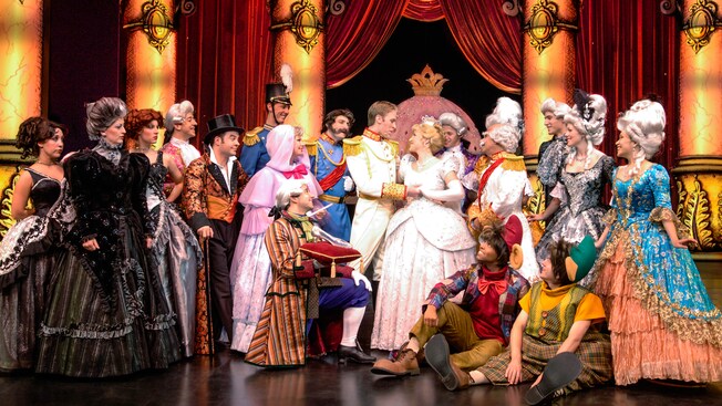 The Prince and Cinderella are surrounded by her evil stepmother and stepsisters and Fairy Godmother