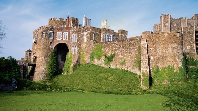 An old castle with grass and moss growing in patches on its walls in Dover England