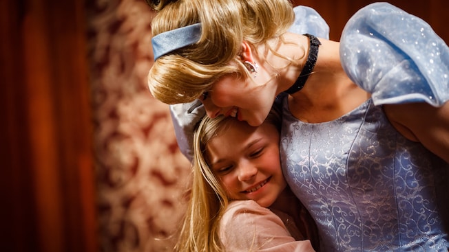 Princess Cinderella and a young girl share a hug at Fantasy Faire