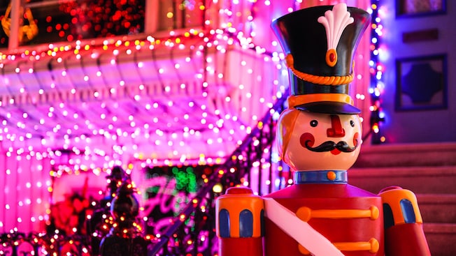 Close-up of a toy soldier with sparkling holiday lights in the background