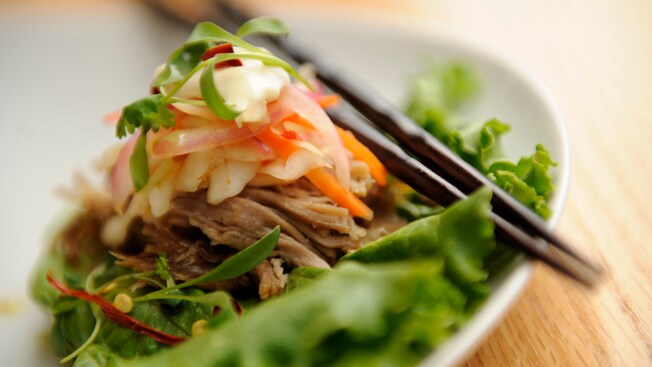 Kimchi slaw topping a serving of roasted pork on a lettuce wrap