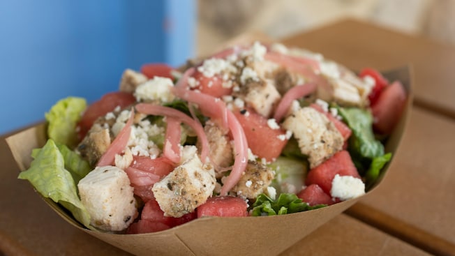 A grilled chicken, feta cheese and watermelon salad sits on a table