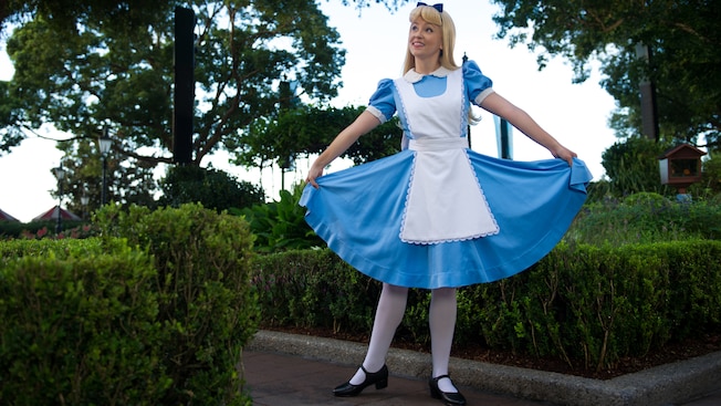 Alice holds her dress to curtsy at Meet a Wonderful Friend in the United Kingdom at Epcot