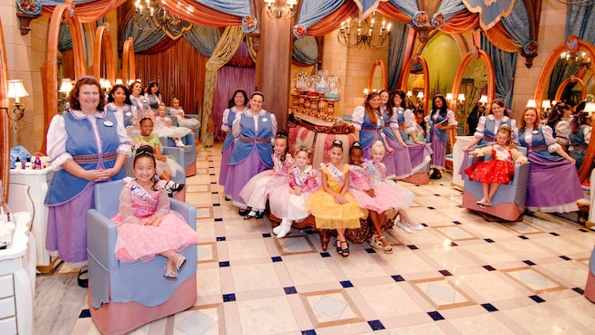 Girls dressed as princesses and their hair stylists at Bibbidi Bobbidi Boutique at Downtown Disney area